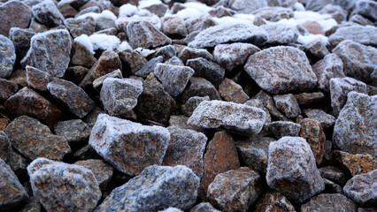 Many stones are covered with frost. Background and texture of stones.