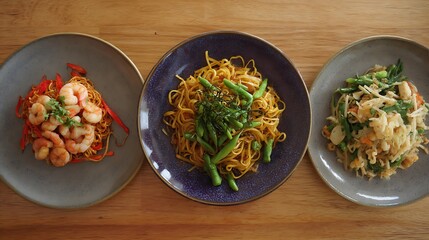 Three plates of stir-fried noodles with various toppings.