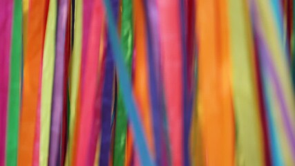 Background video of vertical ribbons of different colors moving in shot, changing pattern. Festive festival decoration fluttering in wind and interaction close up. - Powered by Adobe