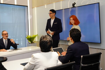 businessman in a suit stands confidently in front of a conference room presenting sales and marketing data, analyzing, and planning the work, continuing his strategy at an executive meeting