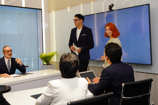 businessman in a suit stands confidently in front of a conference room presenting sales and marketing data, analyzing, and planning the work, continuing his strategy at an executive meeting 