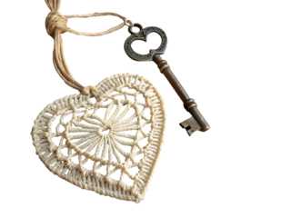 Creamy crocheted heart charm antique key isolated on a transparent background image