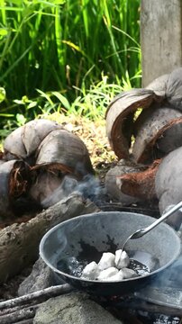 Cooking mie nyemek in a rice field with traditional outdoor style and rustic countryside atmosphere. Indonesian noodle dish prepared in a natural rural environment, showcasing local culinary culture, 