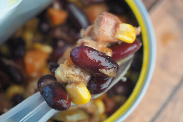 Colorful mixed bean dish served on a spoon outdoors