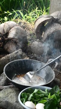 Cooking mie nyemek in a rice field with traditional outdoor style and rustic countryside atmosphere. Indonesian noodle dish prepared in a natural rural environment, showcasing local culinary culture, 