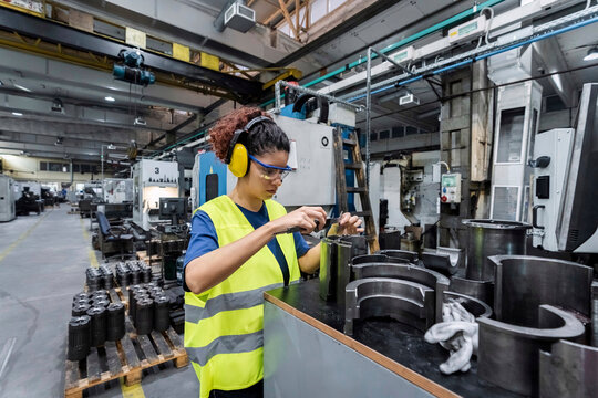 Maintenance engineer in protective workwear working in modern manufacturing industry