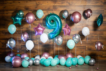 Photo zone with multi-colored balloons and the number nine.