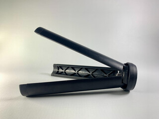 Black mini tripod for camera or mobile phone with flexible legs and flat head isolated on white background