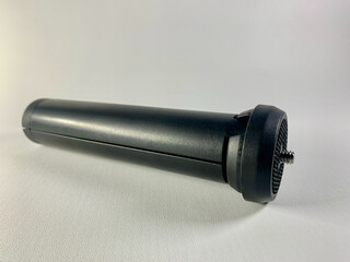 Black mini tripod for camera or mobile phone with flexible legs and flat head isolated on white background