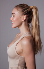 Fototapeta premium Elegant side view of a beautiful white woman showcasing her natural features and long hair in a soft neutral setting during daylight