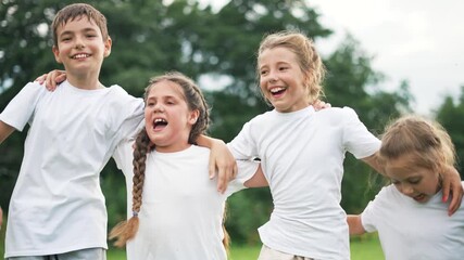 Children hug and laugh together in sunlit park, child and kid forming close friend group, friendship shown by arms around shoulder, smile and laugh during playful group play outdoor with joyful energy