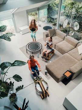Mother and daughters exercising together at home in living room