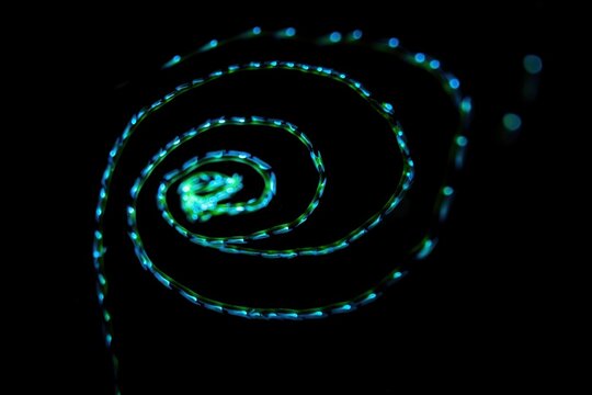 Swirling Blue and Green Light Display on Dark Background
