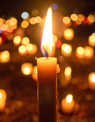 Burning candle amidst many lights
