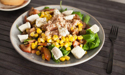 Plate of salad with tuna, corn, tomatoes and arugula