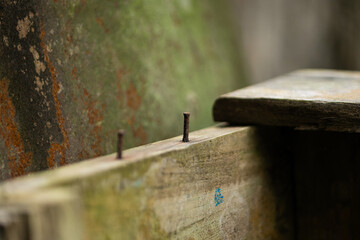 Close-up of rusty nails in an old wooden plank. Construction, rustic, and grunge background.