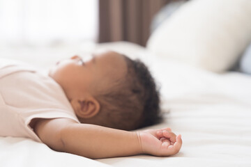 Newborn health care. Newborn baby sleeping on bed. Hands and soft skin of newbord baby during lying on white blanket