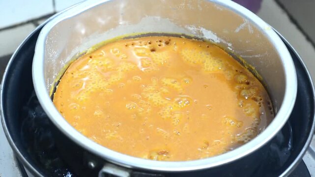 Traditional honeycomb cake making process with mixed batter and homemade baking preparation. Indonesian sweet dessert cooked using authentic recipe, featuring caramel texture, culinary craftsmanship, 