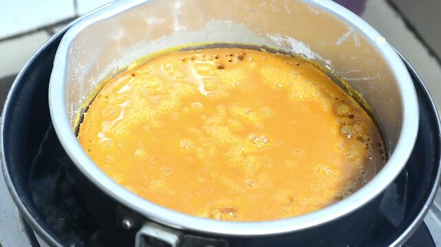 Traditional honeycomb cake making process with mixed batter and homemade baking preparation. Indonesian sweet dessert cooked using authentic recipe, featuring caramel texture, culinary craftsmanship, 