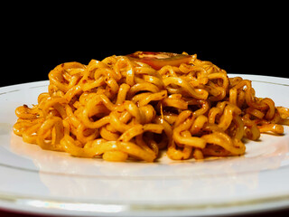 The display of Indonesian fried noodles on a white plate with a black background