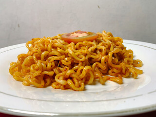 The display of Indonesian fried noodles on a white plate with a white background
