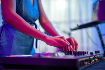 Close up of woman artist DJ mixing and scratching music mixer controller. 
