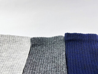 Close-up of three pairs of ribbed socks in gray, white and navy blue