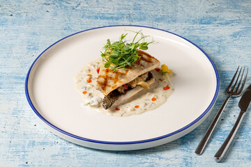 Grilled sea bream fillet served with creamy white sauce