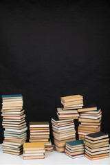Stacks of educational books for learning on a black background