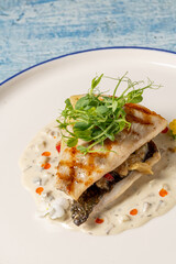 Grilled sea bream fillet served with creamy white sauce