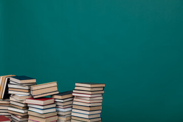 Stacks of educational books for teaching in the school library on a green background
