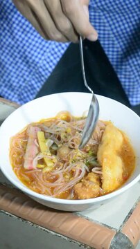 Homemade seblak cooking process with various toppings in a home kitchen. Popular Indonesian spicy street food prepared with authentic ingredients, flavorful seasonings, noodles, crackers, and assorted