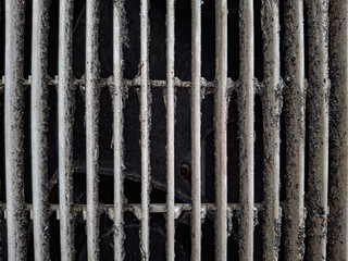 A gritty close-up of a dirty air conditioner or fan vent covered in dust and grime. The image highlights a need for cleaning, representing poor air quality or maintenance issues