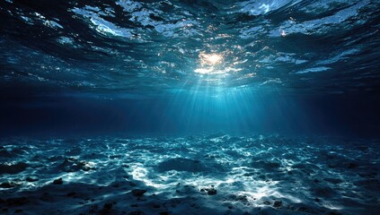 Obraz premium Sunlight beams through deep ocean water, illuminating the seabed
