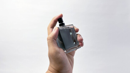 Hand Holding Perfume Spray Bottle - Isolated on a White Background