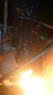 Traditional goat singeing process to remove fur before meat preparation. Rural livestock handling activity using fire technique in an outdoor environment, showcasing authentic farming practices, anima