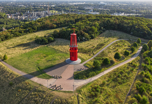 Aerial view of Das Geleucht memorial of Ruhr region contrasting against the green landscape, with industrial structures visible in the background, Moers, North Rhine-Westphalia, Germany.