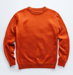 Fototapeta premium Orange crew-neck sweater, laid flat on a white surface