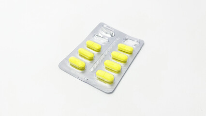 Yellow Pills and Empty Pills in Blister Pack - Isolated on White Background