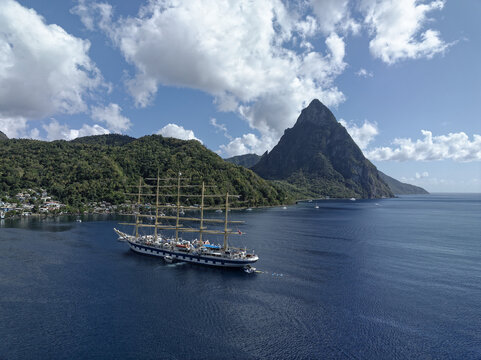 Aerial view of a majestic tall ship sailing near the Pitons, its white sails contrasting against the deep blue sea, Soufri&Atilde;&uml;re, Saint Lucia.