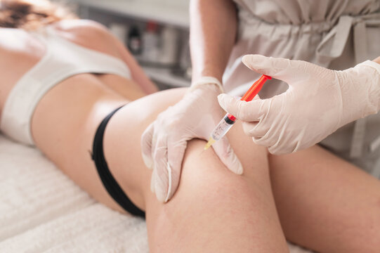 Injections of lipolytic into abdomen for weight loss and muscle definition close-up. doctor in sterile gloves inject lipolytic into hips, butt subcutaneously