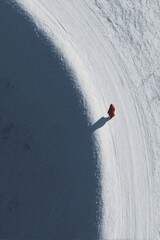 Solitary Hiker on Snowy Slope Under Bright Sky