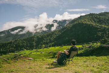 ecology travel with man solo travel and camping outdoor relax in rice field at chiangmai thailand in raining season