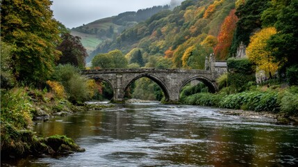 Fototapeta premium Beautiful Autumn Landscape With a Stone Bridge Over a Tranquil River at a Picturesque Location in the Countryside