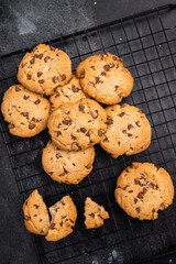 Baked Chocolate chip cookies on steel rack. black background. top view