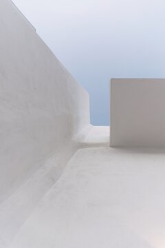 Minimalist view of a whitewashed building in Chora Donousa, Cyclades, Greece, captured from a looking-up perspective. 