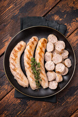 Grilled Sausages with forcemeat mincemeat and herbs in plate. wooden background. top view
