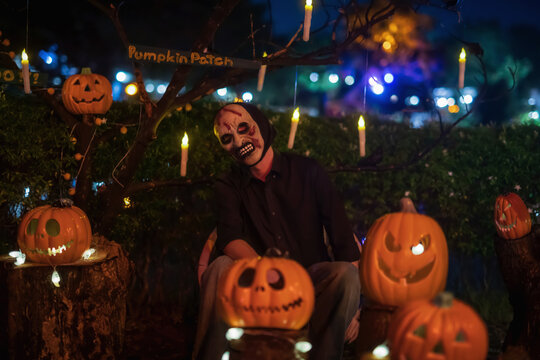 Scary mask devil ma sit by pumpkin lantern with light up candle