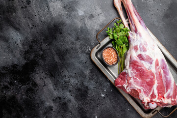 Uncooked whole mutton leg, raw organic lamb meat. black background. top view