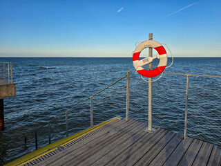 life buoy on the pier with baltic sea in the background 
